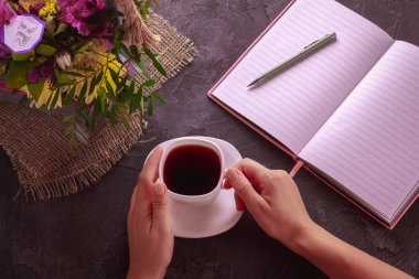 Bir kızın elinde bir fincan siyah çay