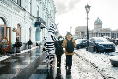 Mutlu turist Petersburg döşeli sokaklar (Griboedova kanal ve Nevsky Prospekt'e) Kazan Katedrali yanında yürümek karlı yağmurlu havalarda, Saint-Petersburg, Rusya Federasyonu