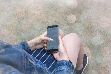 Cep telefonu arka plan bulanık üzerinde kızın elinde kadın ışıklar bokeh yumuşak odak, smartphone arıyor vintage