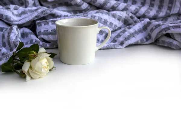 Summer or spring composition - cup of coffee, flowers and plaid on white background, copy space.