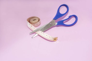 Pembe arka plan üzerinde izole edilmiş makas kesme bant ölçüsü.