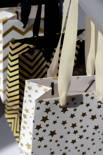 白い背景に日光の下でショッピングバッグ ギフトボックス 黄金の星 黒の幾何学的な線 ファッションモダンなデザイン — ストック写真