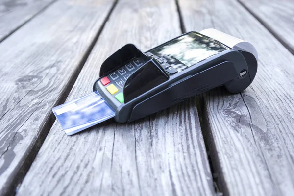 POS terminal, hand swiping credit card, payment with NFC tecnology on wooden background — Stock Photo, Image