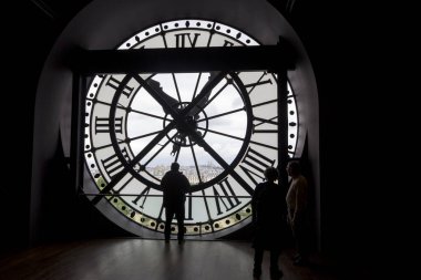 Paris, Fransa - 9 Mayıs 2019: Orsay Müzesi'nde yuvarlak pencereye bakan roma rakamları ve silueti ile ünlü saat, Paris, Fransa.