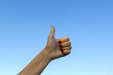 Mavi gökyüzü arka planda iyi veya ok gösteren başparmaklar
