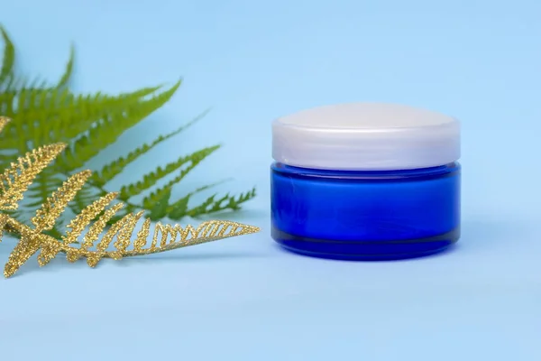 Lege Blauwe Crème Jar Lichte Achtergrond Met Groene Gouden Fern — Stockfoto