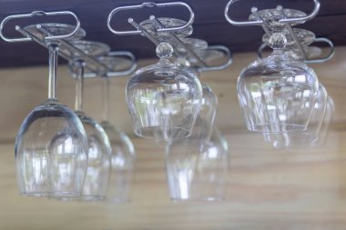 Temiz boş şarap bardakları, arka arkaya konyak bardakları hafif güneş ışığı raf çubuğunda asmak