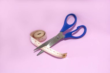 Pembe arka plan üzerinde izole edilmiş makas kesme bant ölçüsü.