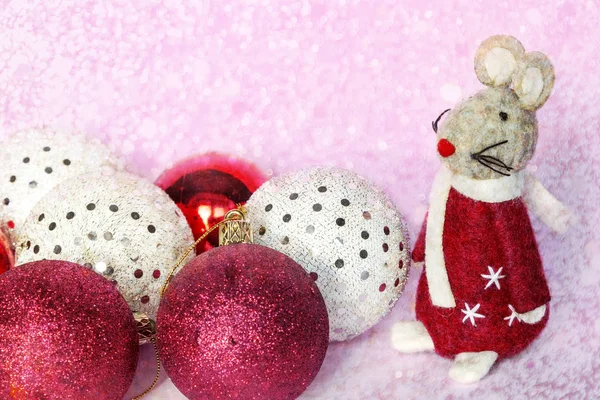 Cute mouse toy with christmas baubles balls on blurred christmas background with lights bokeh. Xmas rat is symbol of New year 2020 according to Chinese calendar.