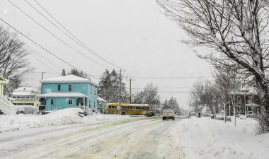 Bu kar yağıyordu ve otobüs sokağın köşesinde kapısı oldu. Mavi bina manzara renk bir dokunuş verdi. Roxton Falls, Quebec, Kanada; 14 Mart 2018.