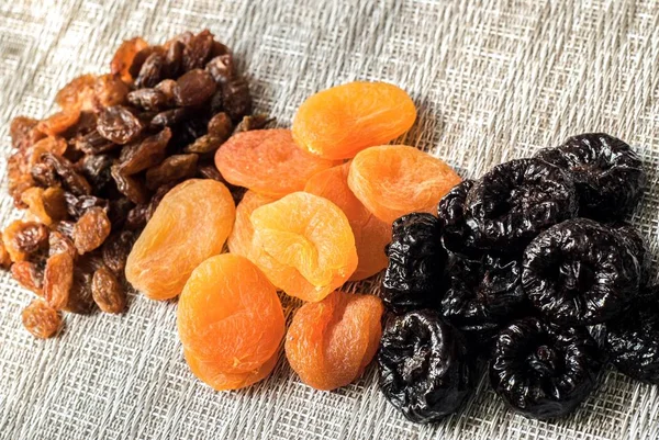 Dried plums, kuraga and raisins on a woven cloth