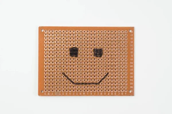 Blank circuit board with emoji face made of resistors