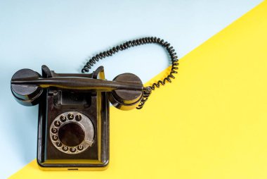 Vintage siyah telefon ile bir kulaklık ve mavi ve sarı sarmal tel kablo