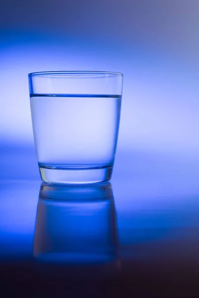 Glass of water with abstract blue light reflections