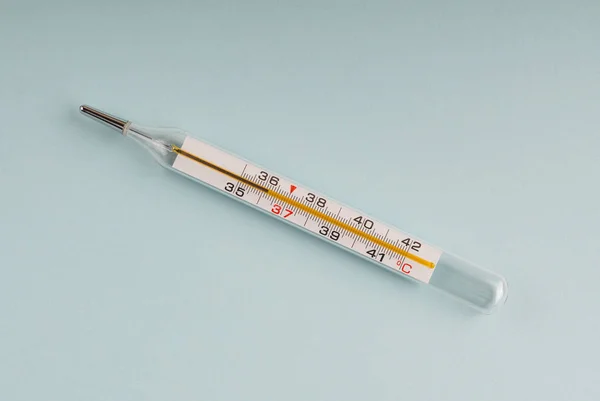 Traditional medical thermometer on blue.