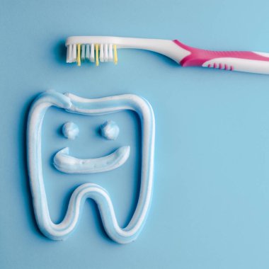 Mavi pembe bir toothbrushe ile gülümseyen bir diş şeklinde diş macunu. Mavi diş macunu. Dişlerle ilgili sağlık bilgisi.
