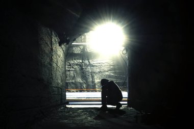 Bulanık bir yeraltı koridorunda bir adam. Yeraltı koridorunda çömelmiş bir adamın bulanık görüntüsü.