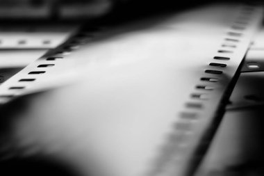 Görüntü yansımaları olan siyah-beyaz negatif film. 35 mm negatif film. Sığ alan derinliğine sahip fotoğraflı film görüntüsü.