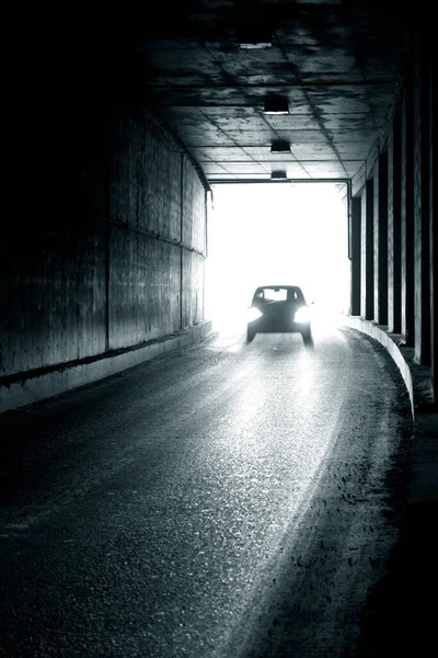 A moving car entering a dark tunnel in blur. Blurry image of a moving car.