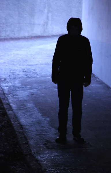 Dark silhouette of a person in a tunnel