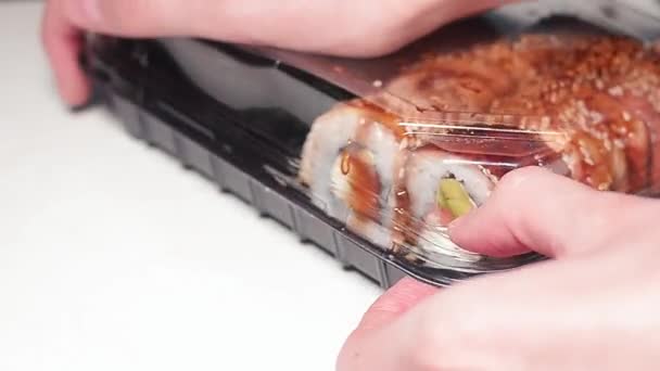 Frau schließt Plastikbox mit frischem japanischen Sushi. — Stockvideo