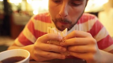 Hipster adam lezzetli sulu tavuk döner bir çay ile eğleniyor yiyor.