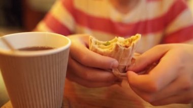 Pita ekmeği ile bir çay ya da kahve kafede oturan lezzetli shawarma yiyerek beyaz delikanlı. Closeup çekim.