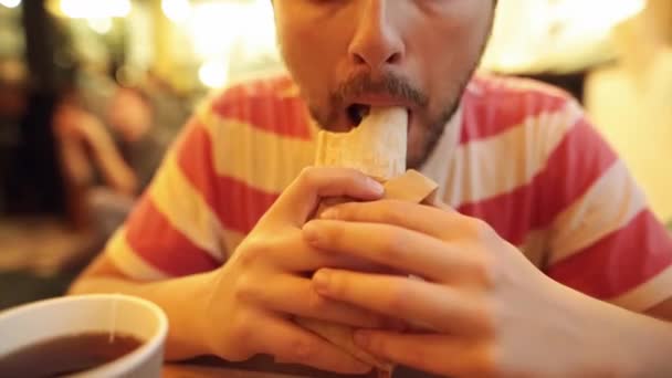 Primer plano de hipster barbudo hambriento comiendo un delicioso shawarma de pollo . — Vídeos de Stock