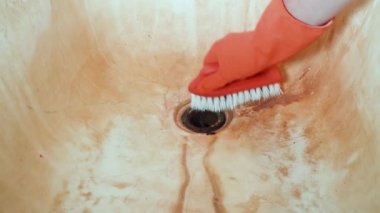 A mans el Kırmızı lastik eldiven fırçalayın fırça ile banyo lavabo temizler. Genel ev temizliği.