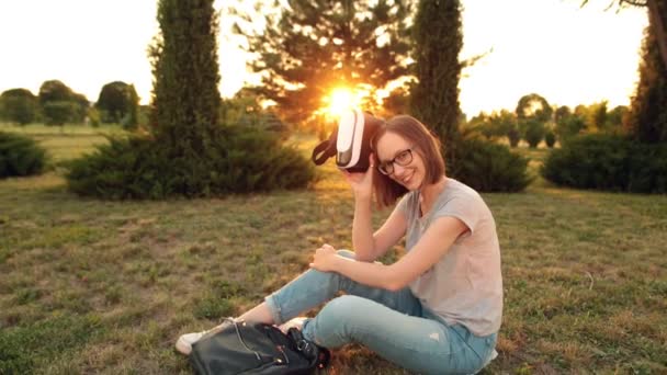 Chica estudiante sonriente utiliza unas gafas de realidad virtual en la noche . — Vídeos de Stock