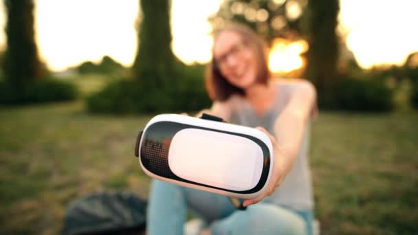 快乐的白种女人在相机上展示了一个虚拟现实的眼镜。选择性聚焦. — 图库视频影像