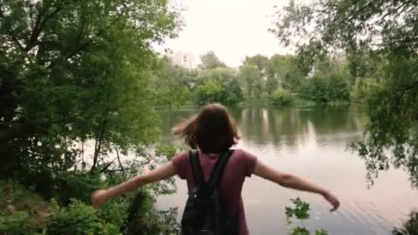 Visão traseira da mulher hipster com as mãos bagpack para cima. Conceito de liberdade . — Vídeo de Stock