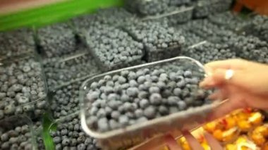 Eller bir süpermarkette yabanmersinli berry seçer.