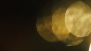 Parlak sıcak bokeh ve ışık darbeleri karanlıkta yavaş yavaş sızıntı.