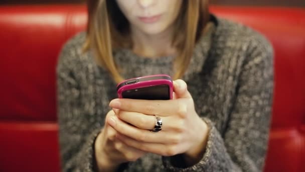 Ung kvinna i glasögon textning på en smartphone. — Stockvideo
