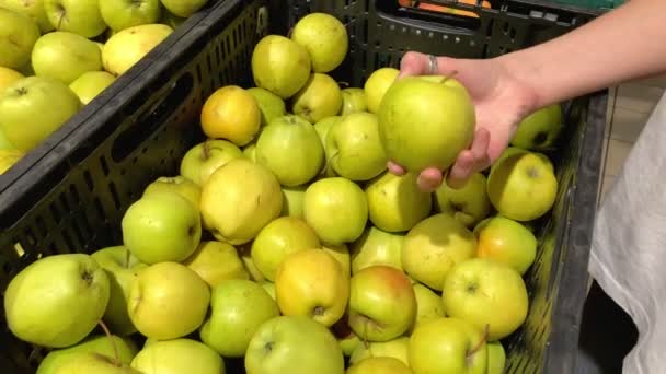 Junge Frau, die in einem Supermarkt Äpfel aus biologischem Anbau pflückt. 4k-Zeitlupe. — Stockvideo