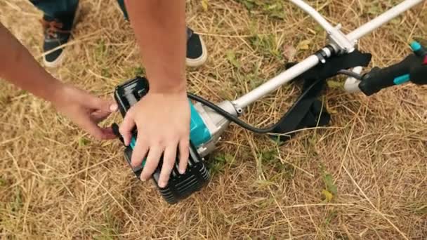 Trädgårdsmästare mannen hand start gas trimmern. Händerna på en professionell gräsklippare. — Stockvideo