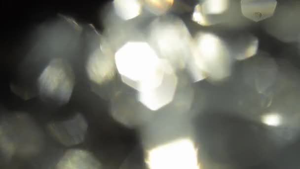 Fond scintillant, bokeh. Diamants suspendus avec reflet brillant clignotant .