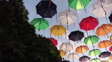 Rüzgarda sallanan gökyüzü karşı sokakta çok renkli şemsiyeler.