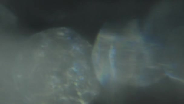 Leuchtender abstrakter Hintergrund mit silbernem und holographisch irisierendem Bokeh. — Stockvideo