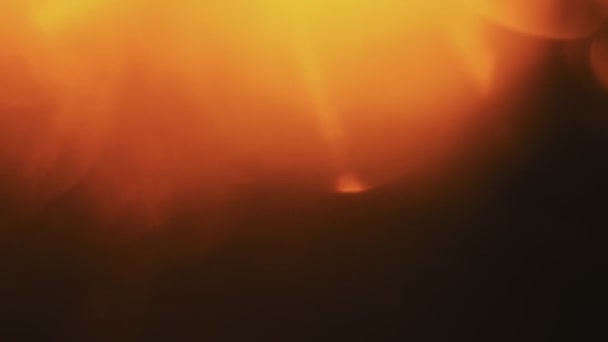 Krásné oranžové světlo úniky v teplém odstínu na tmavém pozadí. — Stock video
