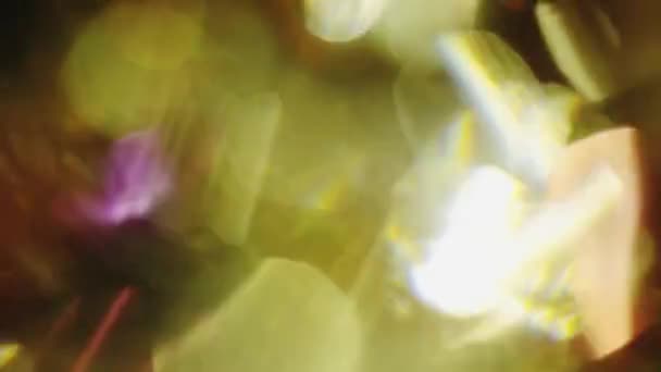 Veelkleurige kristallijne reflecties giet in het donker. Natuurlijke bokeh, licht lekken. — Stockvideo