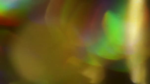 Echte biologische licht lekken, regenbogen en bollen gemaakt met een holografisch folie. — Stockvideo