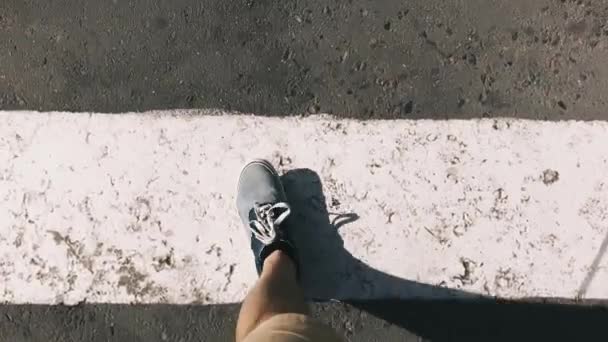 Vue de dessus des chaussures de baskets bleues sur asphalte, passage piéton. Homme marchant dans la ville . — Video