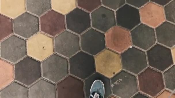 Manliga fötter gå på betongplattor. Utsikt från toppen. Solig dag. — Stockvideo