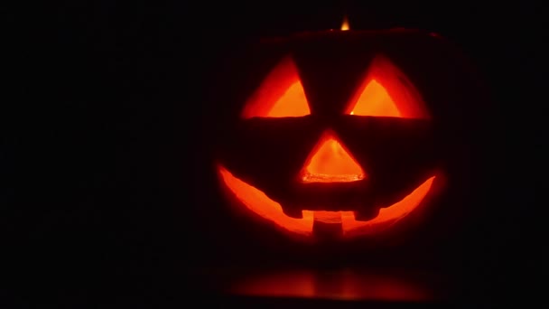 Alguien está soplando una vela encendida dentro de una calabaza de Halloween . — Vídeos de Stock