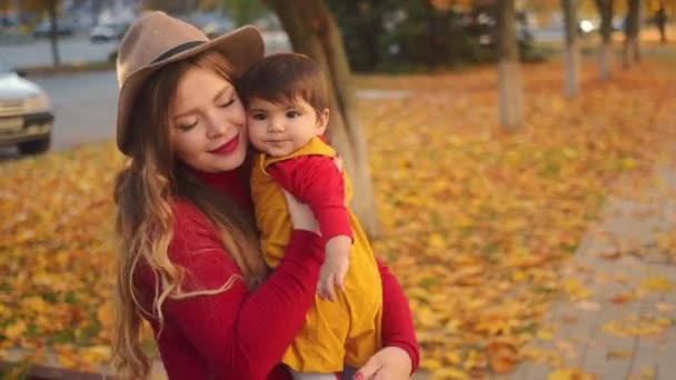 秋の日暖かい日差しの中彼女の小さな女の赤ちゃんと遊んで幸せな若い母. — ストック動画