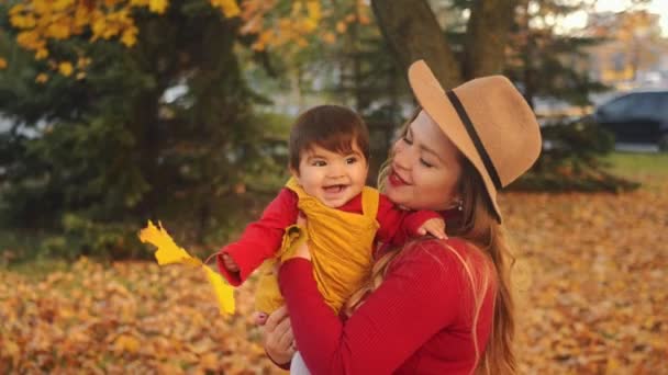 Familia interracial casual. Hipster madre y su mixta carrera bebé divertirse en el otoño parque . — Vídeo de stock