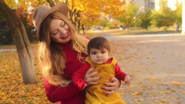 Boldog fiatal kaukázusi anya-anya a többnemzetiségű lánya a szabadban szórakozik. — Stock videók