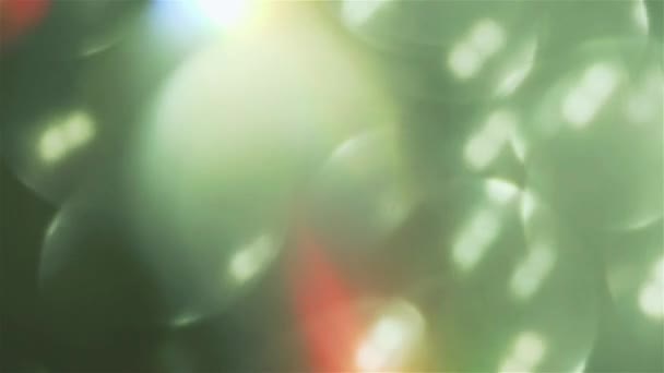 Different colored bokeh pulses. Beautiful light leak in mixed hue on dark background. — Stock Video